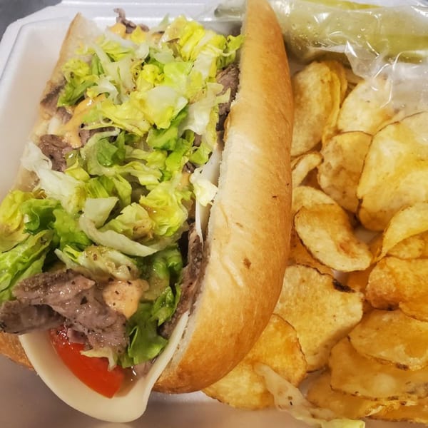 Alicea's NY Bagels & Subs LLC sub-sandwich with steak, lettuce, tomato, cheese, and chips.